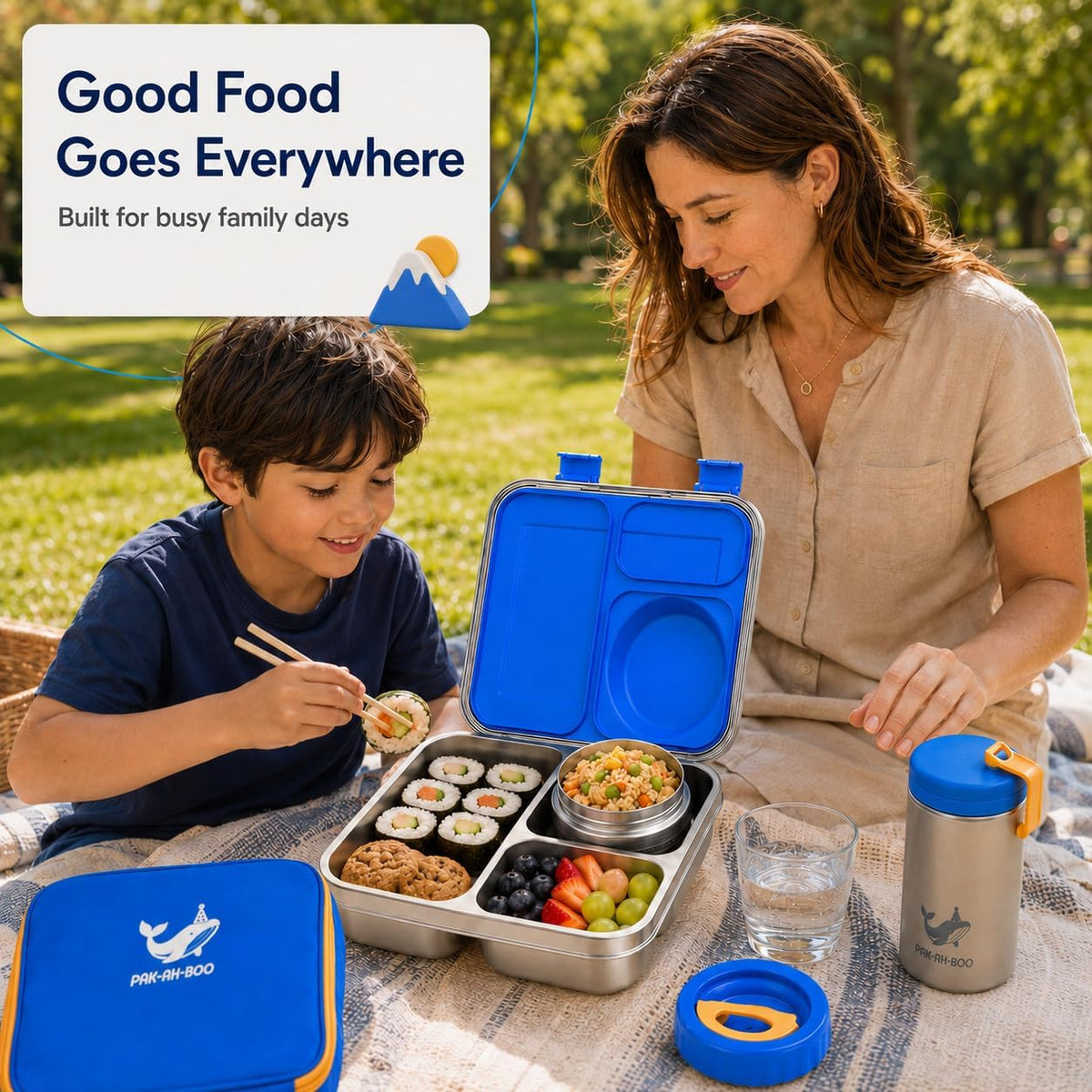Mum and son enjoying a picnic lunch from a blue stainless steel bento lunch box outdoors