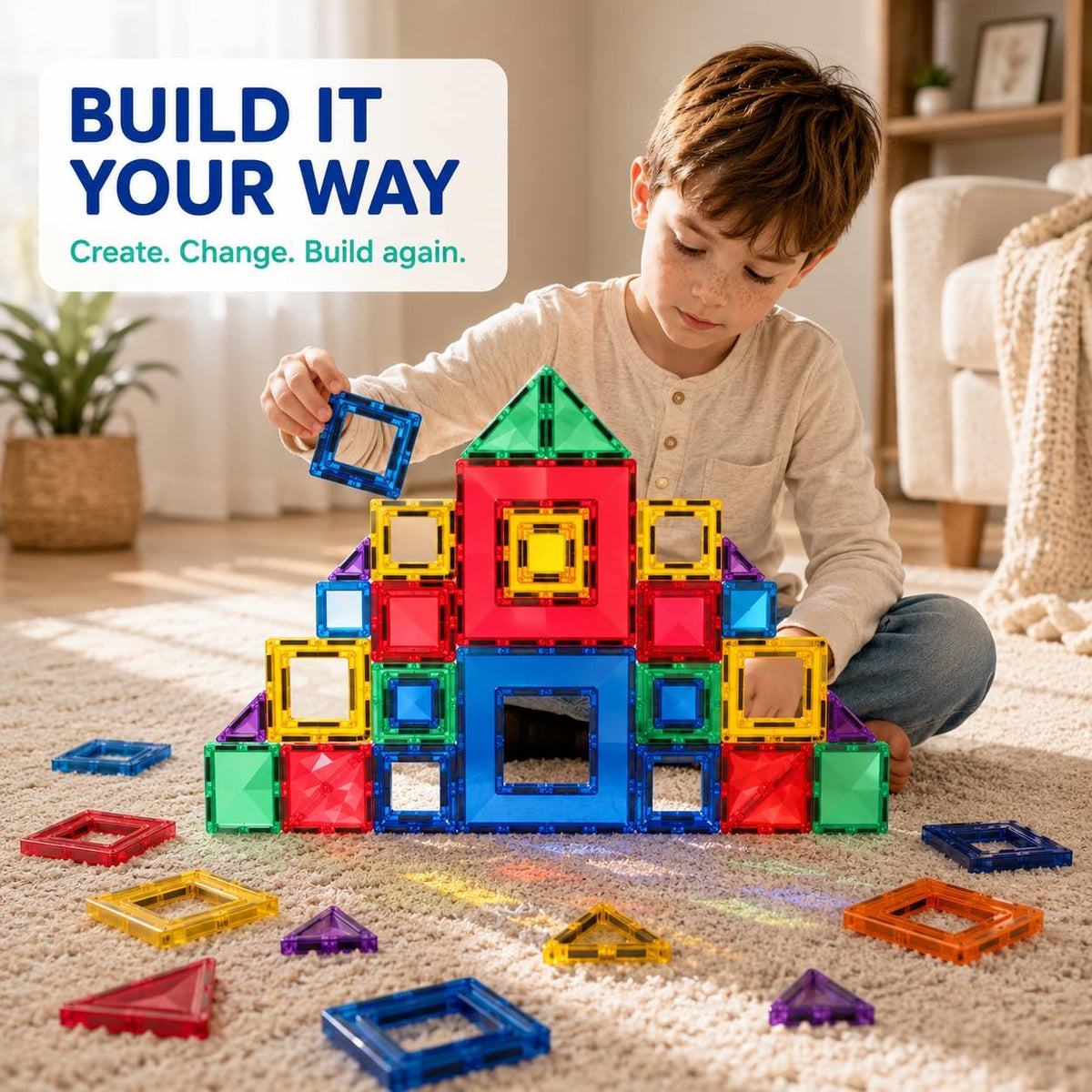 Boy building a magnetic tile tower on the floor – create, change and build again