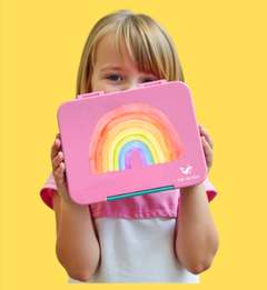 Girl peeking over a pink PAK-AH-BOO rainbow lunch box